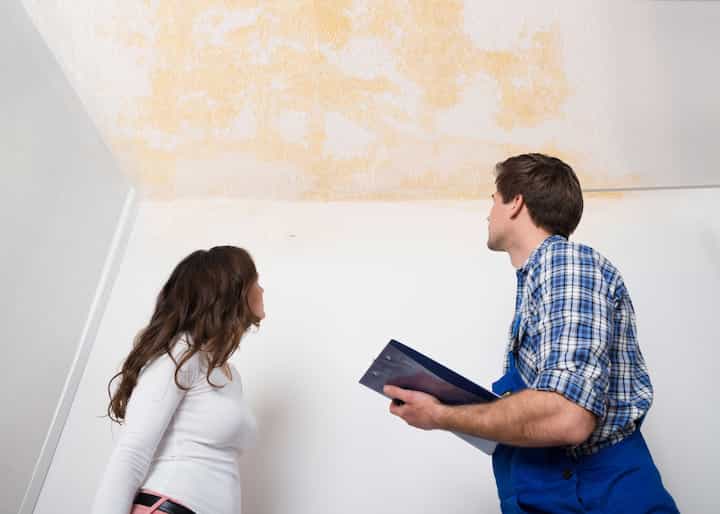 A water damage expert doing an assessment and inspection with a woman who has damaged ceiling caused by a water leak in Manchester Township